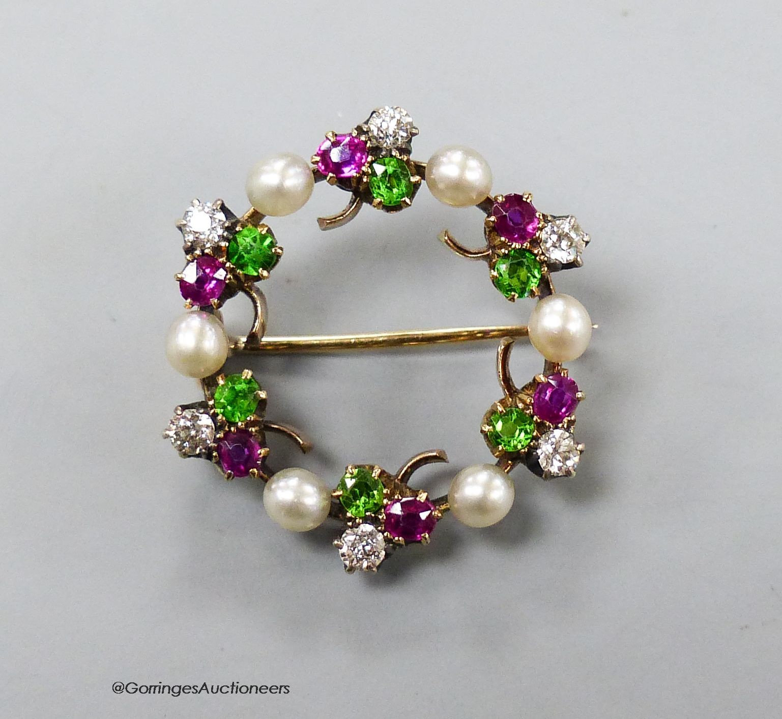 An early 20th century cultured pearl, garnet and diamond set clover cluster openwork brooch, 26mm, gross 6.3 grams.